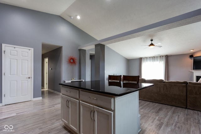 4353 W Parkway Ct, New Palestine, IN 46163 - kitchen with vaulted ceiling, dark countertops, light wood finished floors, a ceiling fan, and open floor plan