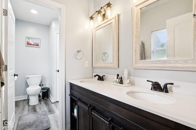 2928 Mounds Rd, Anderson, IN 46016 - bathroom with wood finished floors, double vanity, and recessed lighting