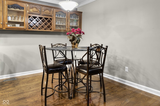 8310 Fall Creek Rd, Indianapolis, IN 46256 - dining area with ornamental molding, dark wood-type flooring, and a dry bar