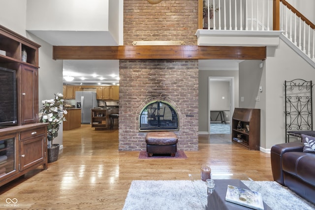 8310 Fall Creek Rd, Indianapolis, IN 46256 - living room with a towering ceiling, a fireplace, and light wood-style floors