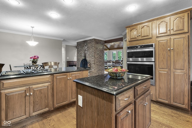 8310 Fall Creek Rd, Indianapolis, IN 46256 - kitchen featuring appliances with stainless steel finishes, light wood-type flooring, a center island, decorative light fixtures, and crown molding