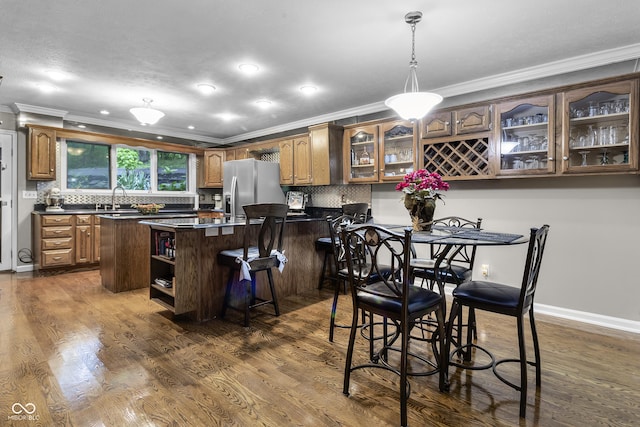 8310 Fall Creek Rd, Indianapolis, IN 46256 - kitchen featuring stainless steel fridge, crown molding, dark countertops, glass insert cabinets, and decorative backsplash