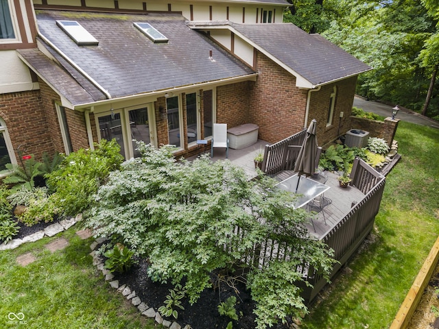 8310 Fall Creek Rd, Indianapolis, IN 46256 - rear view of house with brick siding, a shingled roof, a deck, and a lawn