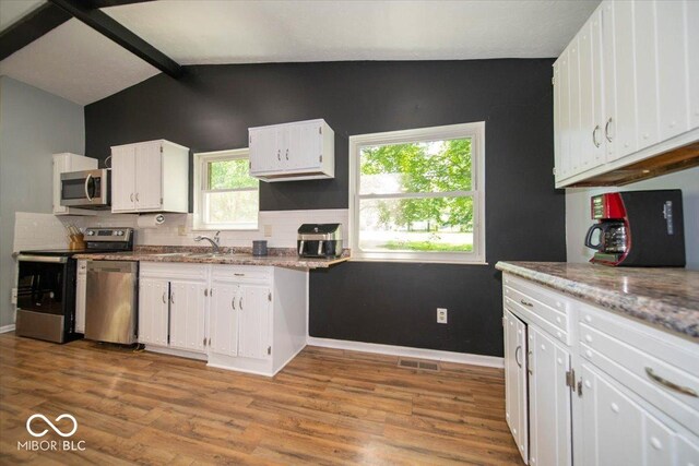 640 Shady Creek Ct, Greenwood, IN 46142 - kitchen with appliances with stainless steel finishes, white cabinets, light wood-style floors, and decorative backsplash
