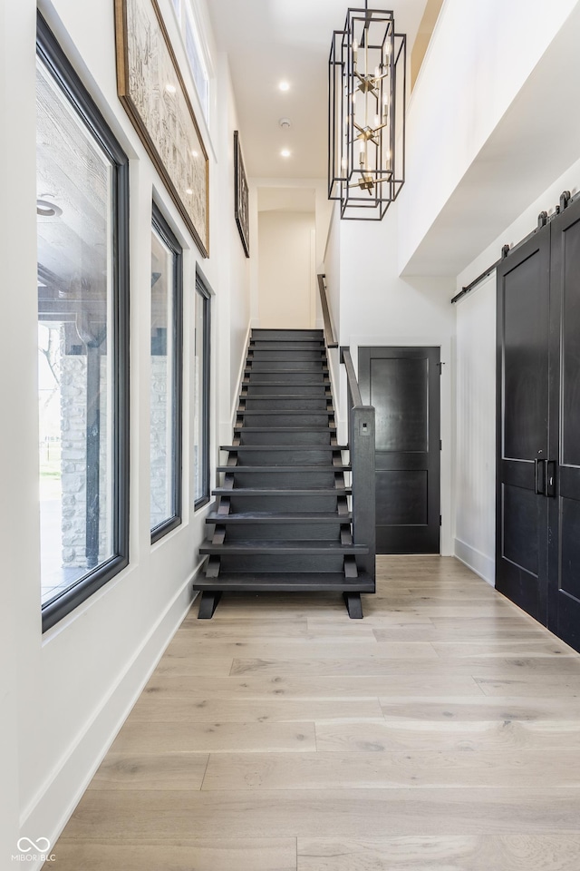 3549 W 131st St, Carmel, IN 46032 - foyer entrance with stairway, light wood-type flooring, a barn door, a chandelier, and recessed lighting