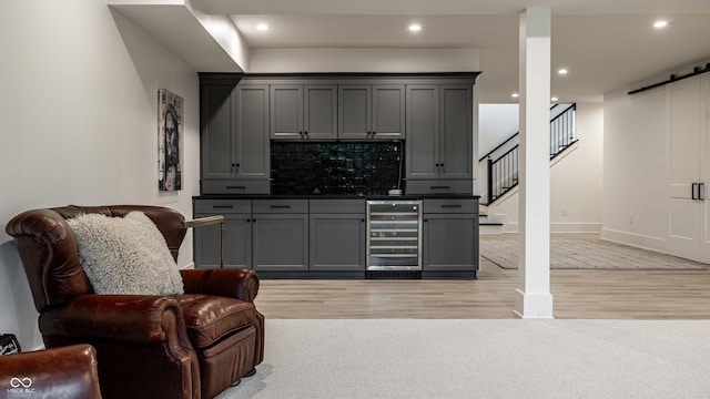 3549 W 131st St, Carmel, IN 46032 - indoor bar featuring beverage cooler, a barn door, light wood-style floors, recessed lighting, and stairway