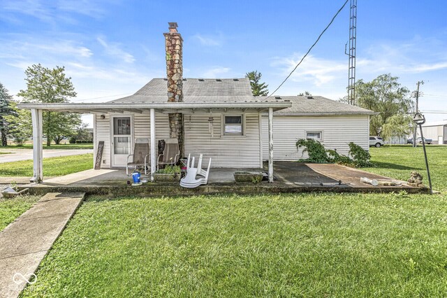 9290 Vine St, Manilla, IN 46150 - rear view of house with a lawn, a shingled roof, and a chimney