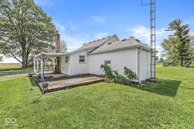 9290 Vine St, Manilla, IN 46150 - rear view of house featuring a patio, a yard, a chimney, and a shingled roof