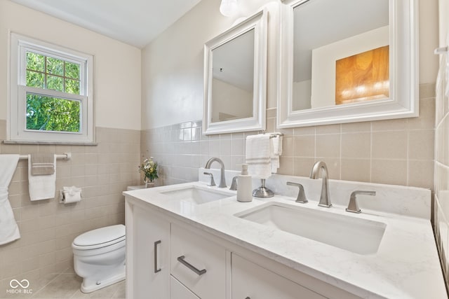 1010 Maple St, Greenwood, IN 46142 - bathroom with double vanity, tile walls, tile patterned flooring, and a wainscoted wall