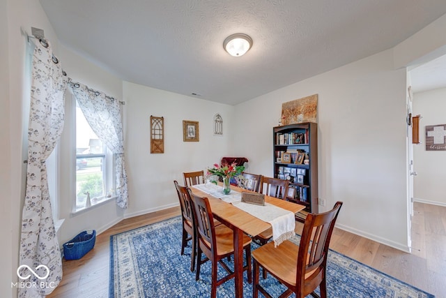 59 Manchester Dr, Trafalgar, IN 46181 - dining area featuring wood finished floors, baseboards, and a textured ceiling