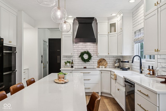 1345 Lewiston Dr, Westfield, IN 46074 - kitchen with premium range hood, black appliances, light countertops, a kitchen bar, and white cabinetry