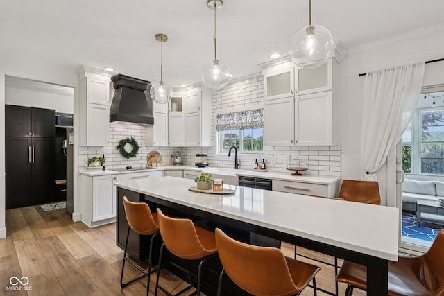 1345 Lewiston Dr, Westfield, IN 46074 - kitchen with custom range hood, black electric stovetop, light countertops, decorative backsplash, and crown molding