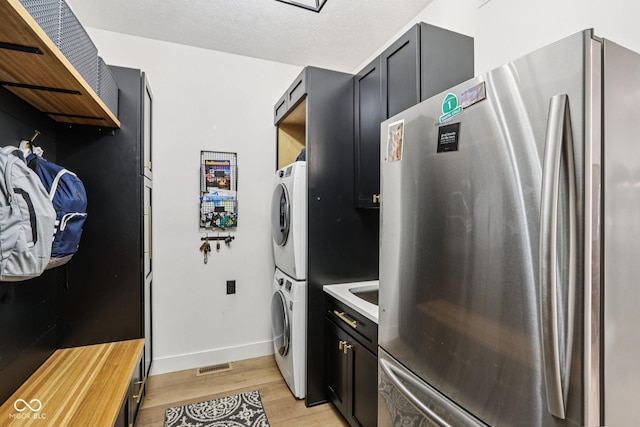 1345 Lewiston Dr, Westfield, IN 46074 - kitchen featuring freestanding refrigerator, stacked washer / dryer, light wood finished floors, open shelves, and dark cabinetry
