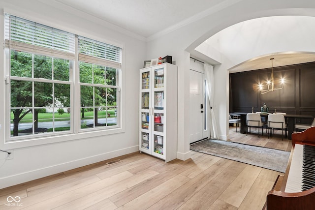 1345 Lewiston Dr, Westfield, IN 46074 - entrance foyer with light wood-style flooring, arched walkways, plenty of natural light, crown molding, and a chandelier
