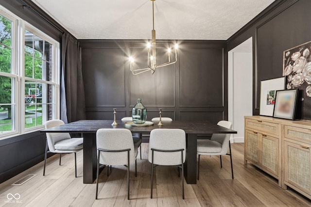 1345 Lewiston Dr, Westfield, IN 46074 - dining area featuring a decorative wall, a chandelier, light wood-type flooring, and ornamental molding
