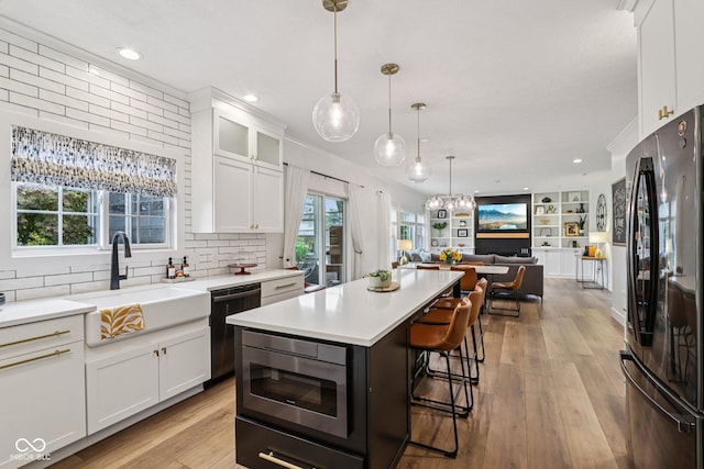 1345 Lewiston Dr, Westfield, IN 46074 - kitchen featuring freestanding refrigerator, dishwashing machine, stainless steel microwave, open floor plan, and white cabinets