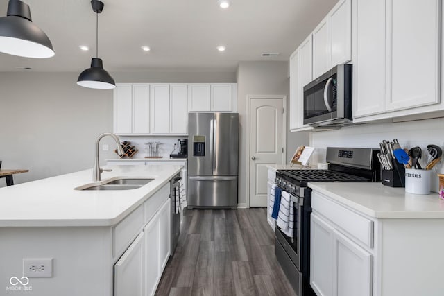 14110 Bay Willow Dr, Fishers, IN 46037 - kitchen featuring appliances with stainless steel finishes, dark wood finished floors, light countertops, white cabinets, and decorative light fixtures