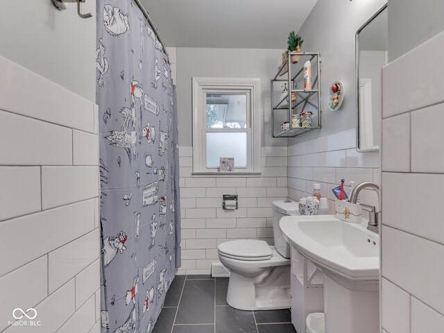 1504 Mcclure Rd, Columbus, IN 47201 - bathroom with toilet, tile patterned floors, tile walls, wainscoting, and a shower with curtain