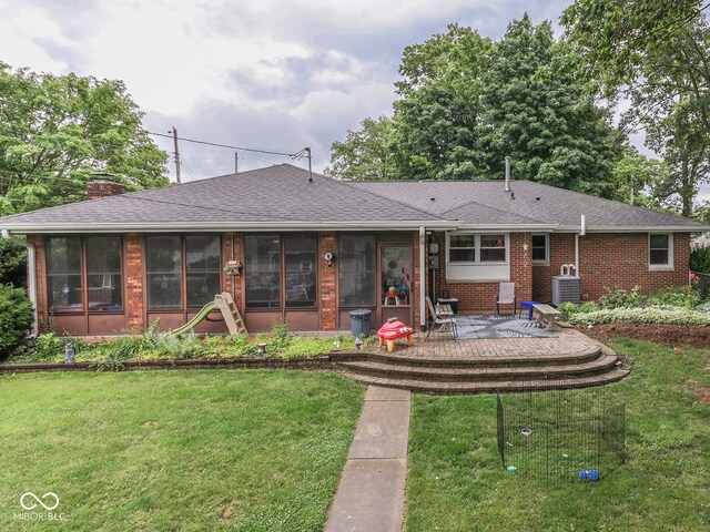 1504 Mcclure Rd, Columbus, IN 47201 - back of property with a sunroom, central AC unit, a lawn, and brick siding