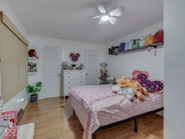 1504 Mcclure Rd, Columbus, IN 47201 - bedroom featuring light wood-type flooring, a ceiling fan, and multiple closets