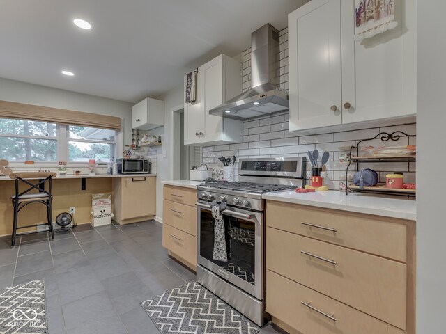 1504 Mcclure Rd, Columbus, IN 47201 - kitchen with stainless steel appliances, wall chimney range hood, backsplash, light countertops, and recessed lighting