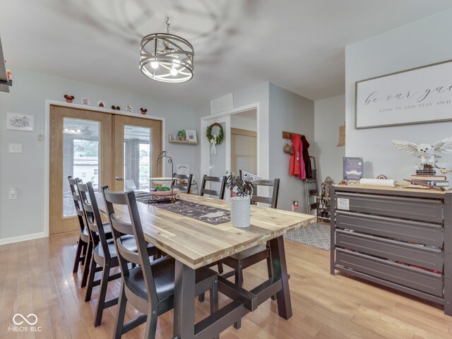 1504 Mcclure Rd, Columbus, IN 47201 - dining space featuring light wood-style flooring, a chandelier, french doors, and baseboards