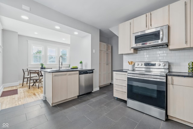2896 Sutherland Ave, Indianapolis, IN 46205 - kitchen with stainless steel appliances, a sink, tasteful backsplash, recessed lighting, and dark countertops