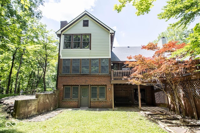 5530 Shawnee Trail S Drive, Indianapolis, IN 46220 - rear view of property featuring a chimney, brick siding, a lawn, and a deck