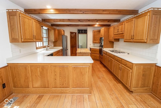 5530 Shawnee Trail S Drive, Indianapolis, IN 46220 - kitchen with light wood-style flooring, a peninsula, beam ceiling, light countertops, and stainless steel appliances