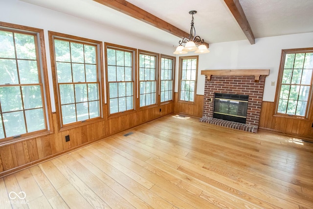 5530 Shawnee Trail S Drive, Indianapolis, IN 46220 - unfurnished living room featuring wood-type flooring, beamed ceiling, a brick fireplace, and wooden walls