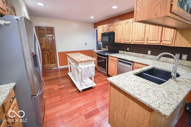 5109 N Weathers Ct, Bloomington, IN 47404 - kitchen with stainless steel appliances, light wood finished floors, light stone countertops, light brown cabinets, and recessed lighting