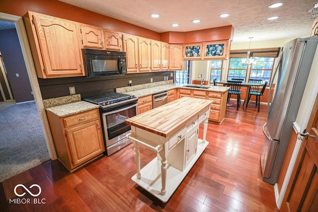 5109 N Weathers Ct, Bloomington, IN 47404 - kitchen with stainless steel appliances, butcher block countertops, a peninsula, backsplash, and dark wood-style flooring