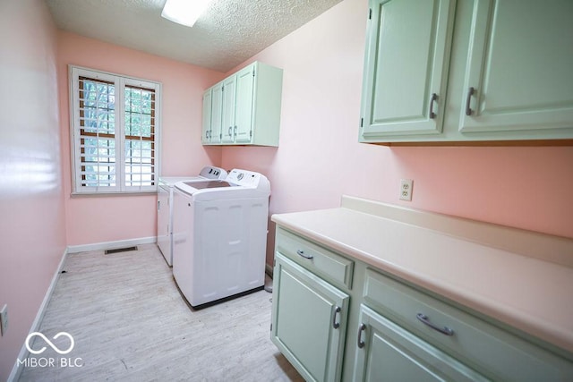 5109 N Weathers Ct, Bloomington, IN 47404 - laundry area featuring cabinet space, separate washer and dryer, a textured ceiling, and light wood-style flooring
