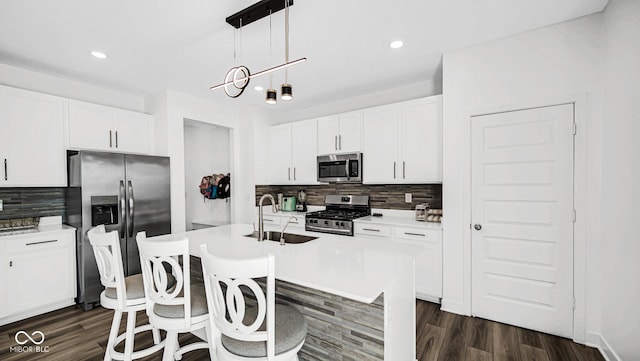 8690 Lester Pl, Pendleton, IN 46064 - kitchen featuring appliances with stainless steel finishes, backsplash, dark wood-style floors, a kitchen island with sink, and recessed lighting