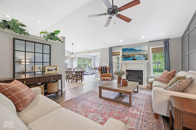3571 S Cedar Creek Ln, New Palestine, IN 46163 - living area with vaulted ceiling, healthy amount of natural light, wood finished floors, a glass covered fireplace, and ceiling fan