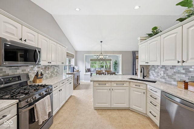 3571 S Cedar Creek Ln, New Palestine, IN 46163 - kitchen featuring stainless steel appliances, vaulted ceiling, a peninsula, white cabinetry, and tasteful backsplash