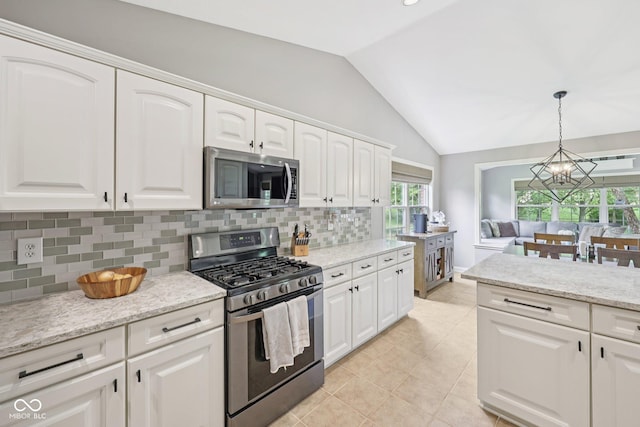 3571 S Cedar Creek Ln, New Palestine, IN 46163 - kitchen featuring appliances with stainless steel finishes, a chandelier, vaulted ceiling, tasteful backsplash, and white cabinets