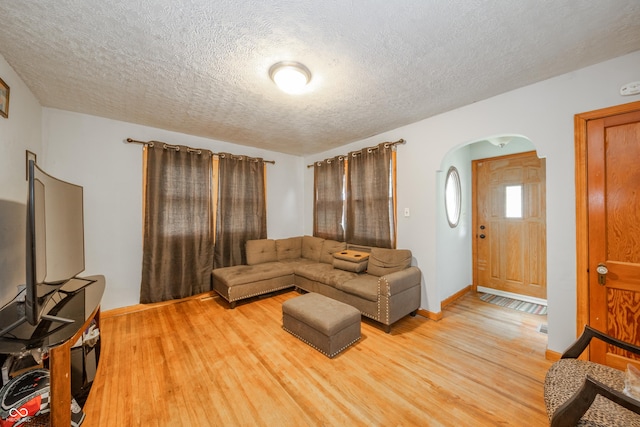 450 Columbia Ave, Tipton, IN 46072 - living area with arched walkways, a textured ceiling, light wood-type flooring, and baseboards