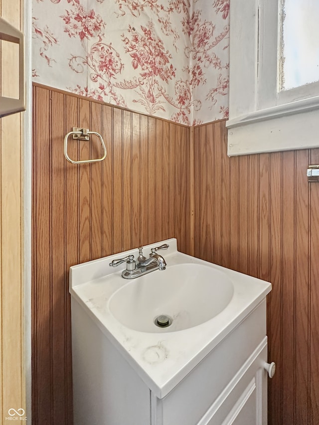 4715 E New York St, Indianapolis, IN 46201 - bathroom featuring wallpapered walls, a wainscoted wall, and vanity