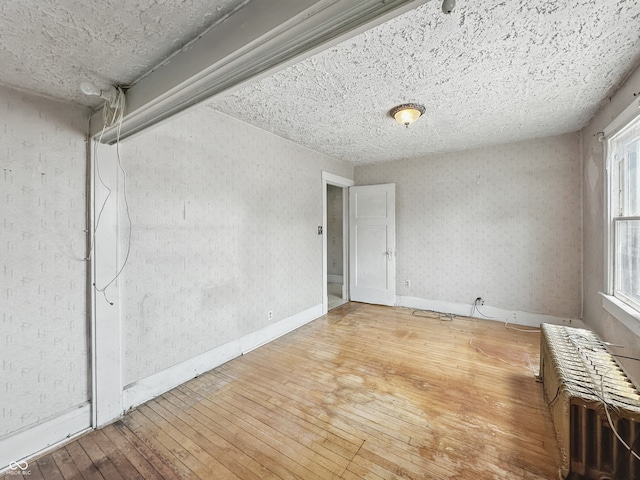 4715 E New York St, Indianapolis, IN 46201 - empty room with hardwood / wood-style floors, baseboards, and radiator