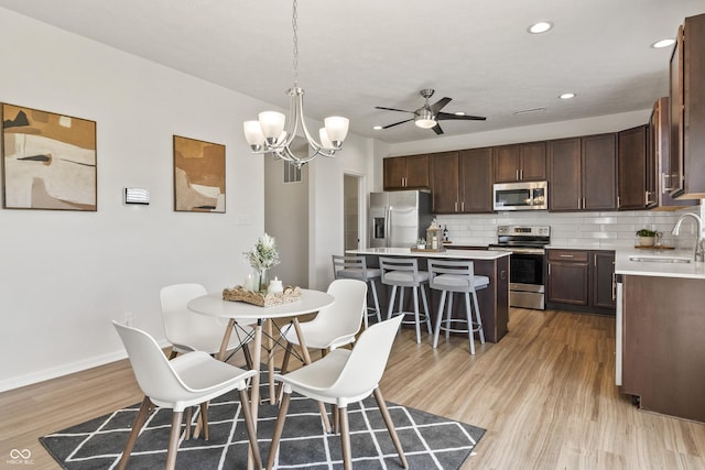 10112 Gallop Ln, Fishers, IN 46040 - dining area with light wood finished floors, ceiling fan, a chandelier, and recessed lighting