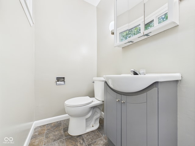 220 Central Ave, Anderson, IN 46012 - half bath featuring baseboards, toilet, vanity, and stone finish flooring