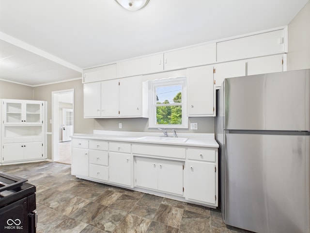 220 Central Ave, Anderson, IN 46012 - kitchen featuring freestanding refrigerator, light countertops, white cabinetry, stone finish flooring, and crown molding