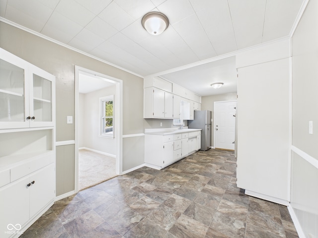 220 Central Ave, Anderson, IN 46012 - kitchen with light countertops, freestanding refrigerator, white cabinetry, stone finish flooring, and crown molding