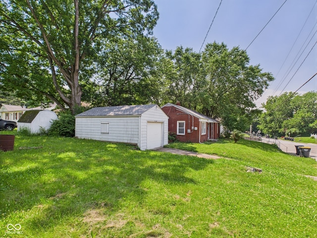 220 Central Ave, Anderson, IN 46012 - view of green lawn featuring a garage, an outbuilding, and view of scattered trees