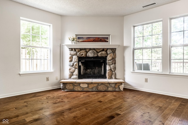 10216 Hatherley Way, Fishers, IN 46037 - unfurnished living room featuring dark wood-type flooring, plenty of natural light, a fireplace, and a textured ceiling