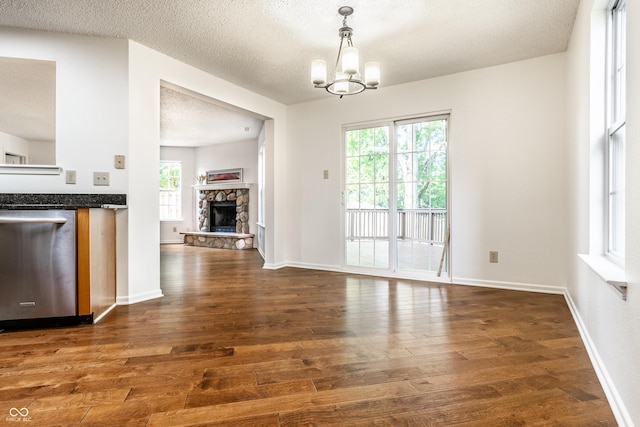 10216 Hatherley Way, Fishers, IN 46037 - unfurnished dining area featuring wood finished floors, a fireplace, a chandelier, and a textured ceiling