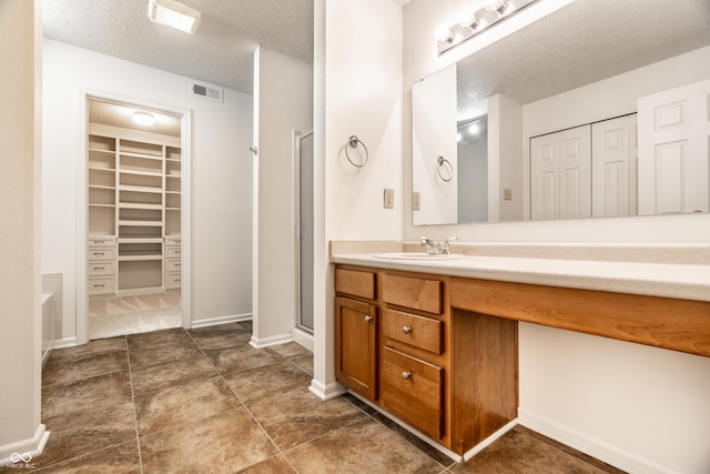 10216 Hatherley Way, Fishers, IN 46037 - bathroom featuring vanity, a textured ceiling, a stall shower, and a walk in closet