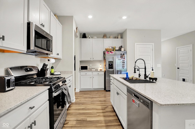 741 Scarsdale Ln, Danville, IN 46122 - kitchen featuring stainless steel appliances, light wood-style flooring, white cabinets, a center island with sink, and recessed lighting