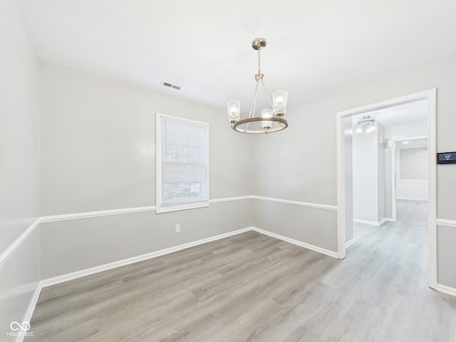 2126 Tartan Rd, Anderson, IN 46012 - spare room with a chandelier and wood finished floors